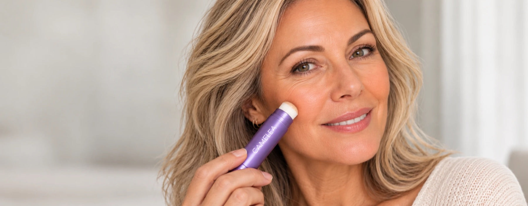 Une femme applique le Stick Teint Adaptatif sur sa joue